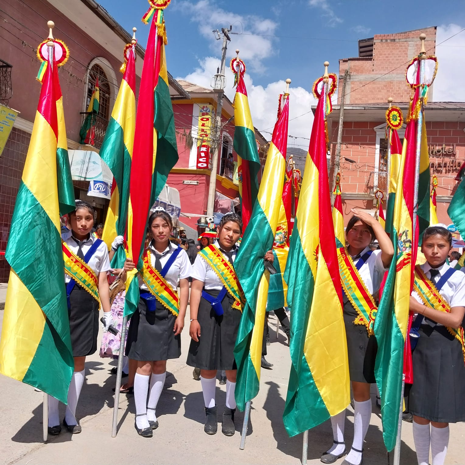 A group of girls holding flags in front of a building.