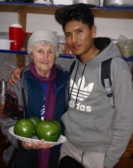 A man and woman holding green apples in a bowl.