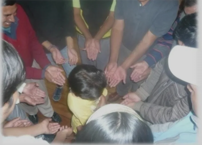 A group of people holding hands in a circle.