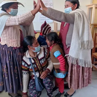 A group of people wearing masks and giving each other a high five.