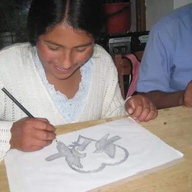 A girl is drawing with pencils on paper.